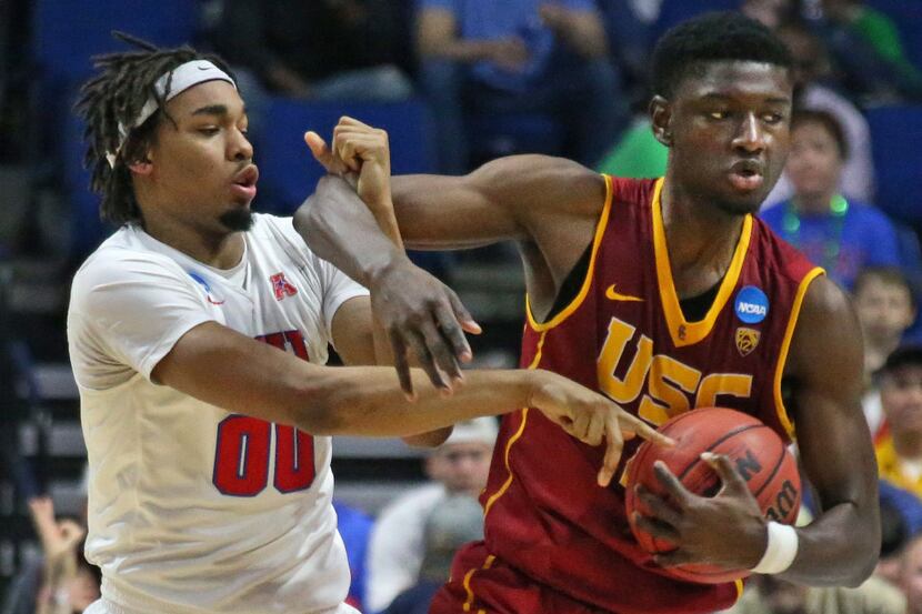 USC forward Chimezie Metu (4) wrestles a rebound away from SMU's Ben Moore (00) in the...