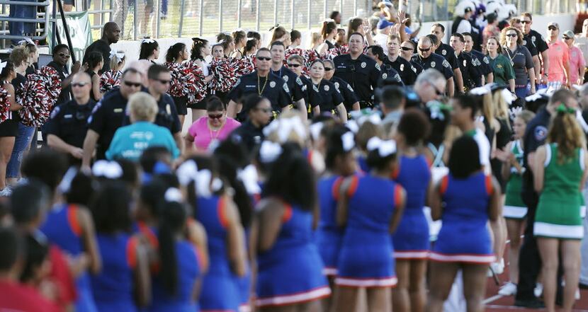 About 400 members of Texas law enforcement agencies marched into UT-Arlington's Maverick...