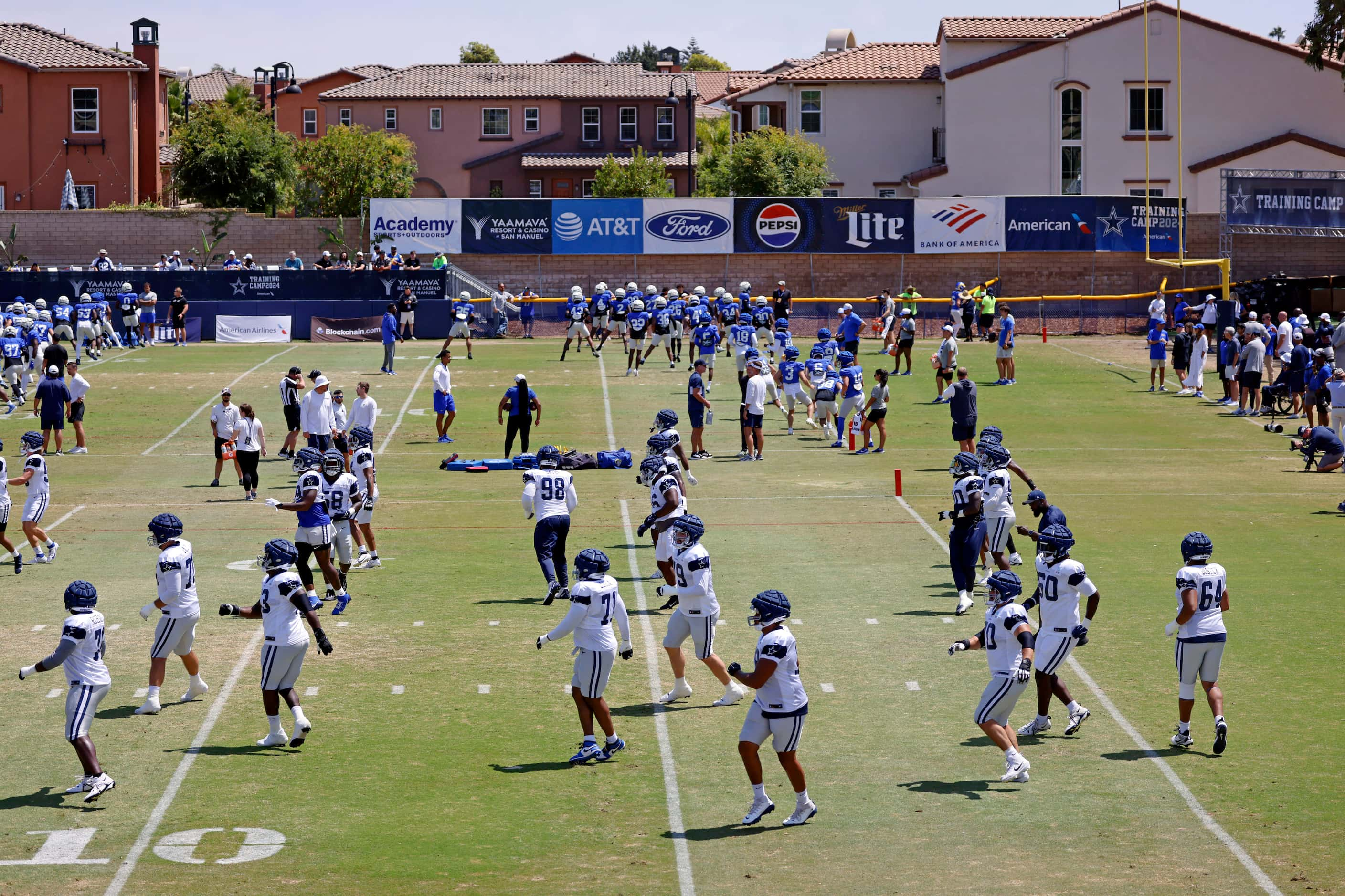 The Dallas Cowboys (foreground) and Los Angeles Rams (background) warm up before facing each...