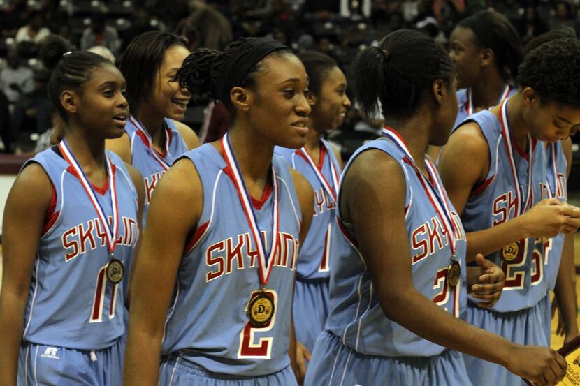 Members of the Skyline girls basketball team are all smiles as they flash their medals after...