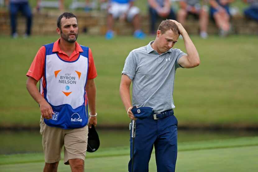 Jordan Spieth (right) rubs his head after he finishes the second round with 5-over par at...