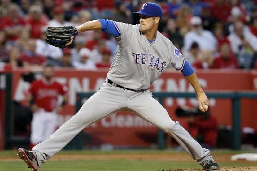 Texas Rangers' Cole Hamels delivers a pitch during the second inning of a baseball game...