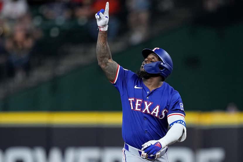 Texas Rangers' Adolis García celebrates after hitting an RBI single during the first inning...