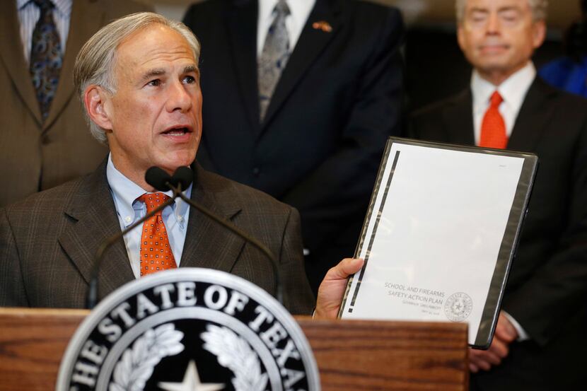 Governor Greg Abbott holds up his School and Firearm Safety Action Plan during a press...