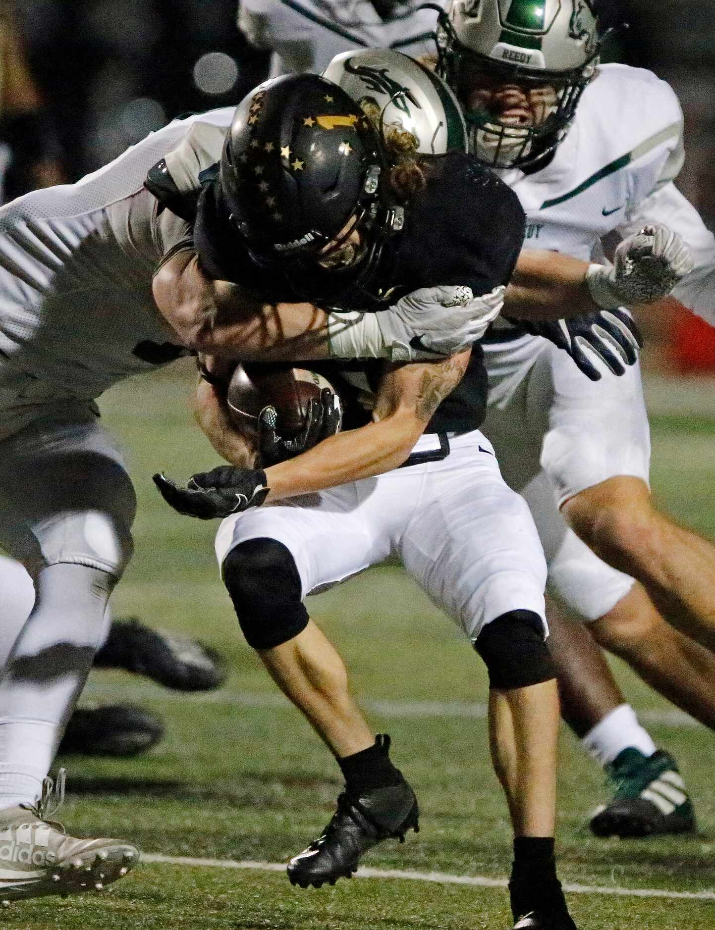 The Colony High School wide receiver Benji Nelson (1) is hit by Reedy High School defensive...
