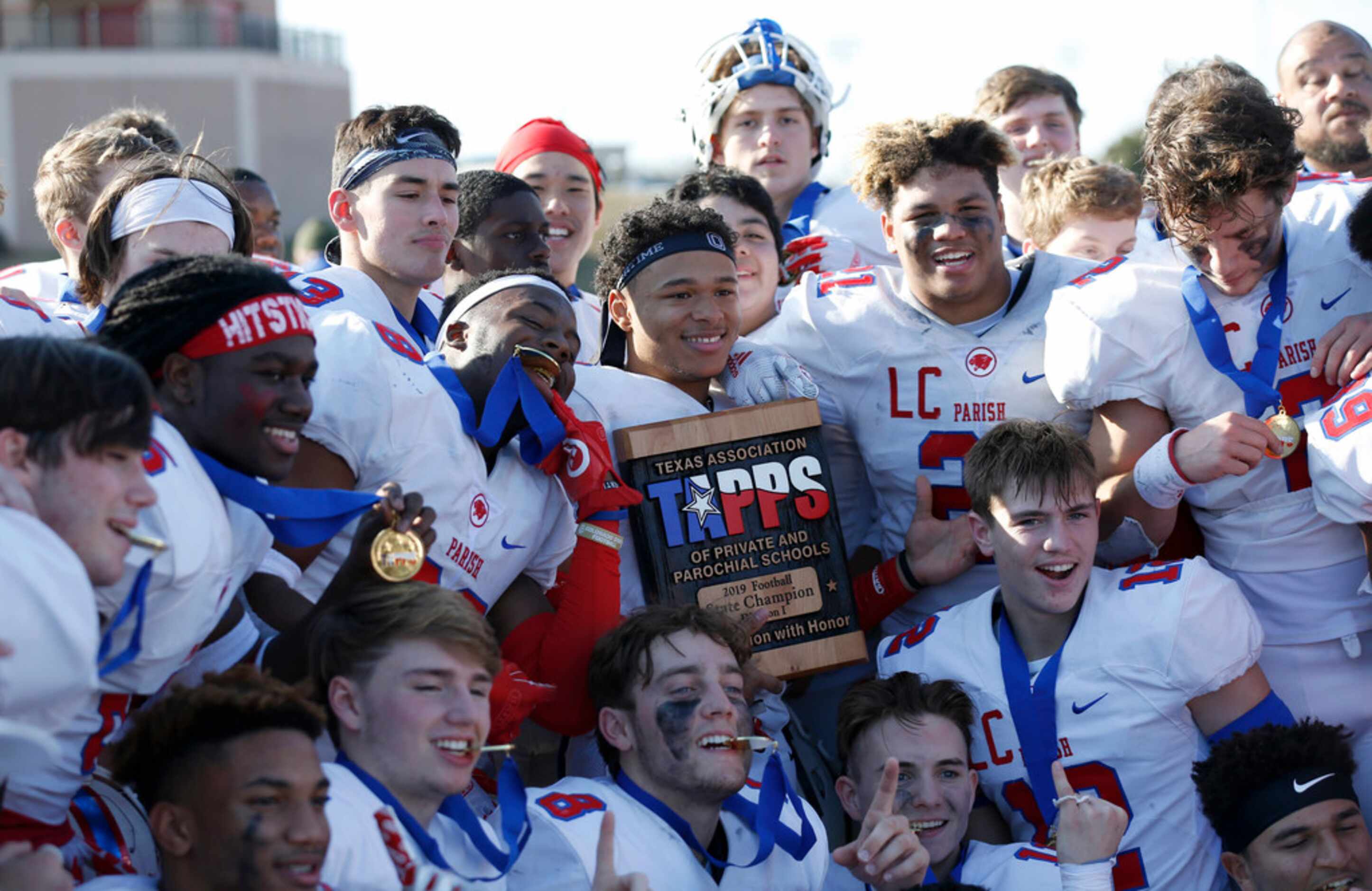 Parish Episcopal's Christian Benson (23) holds up the trophy as he poses for a photo with...