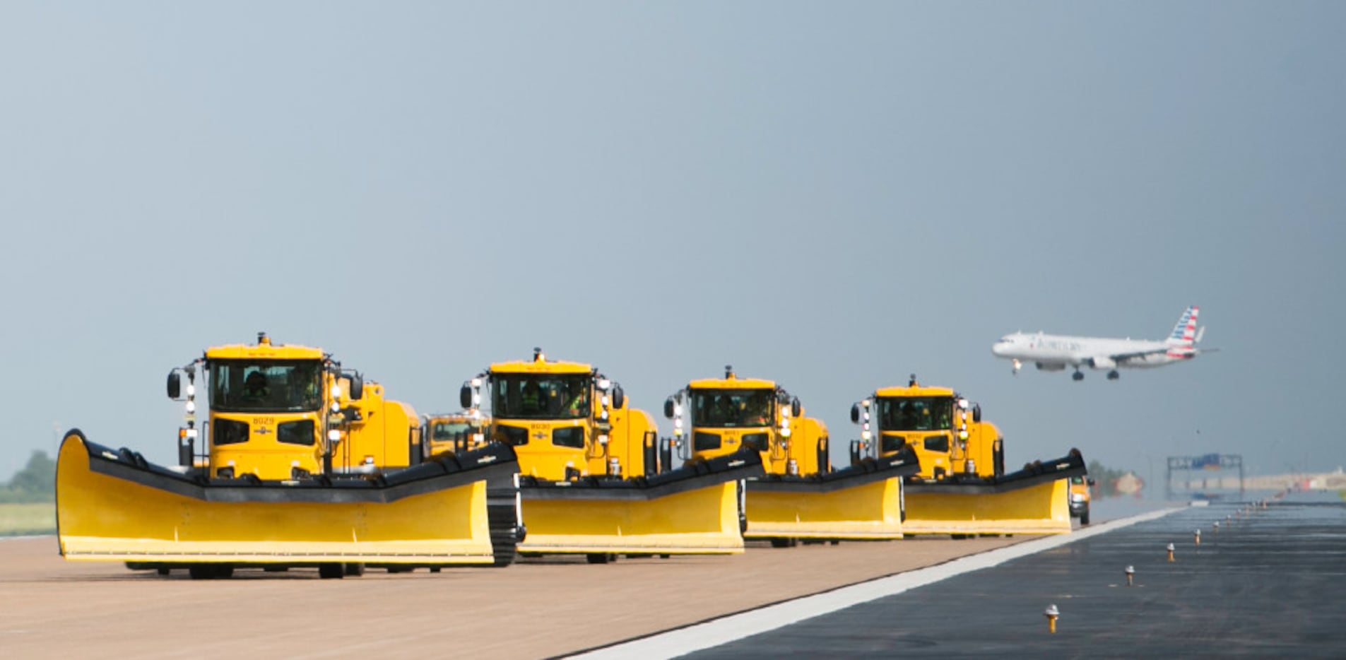 Plows drive down a runway during a training session Wednesday.