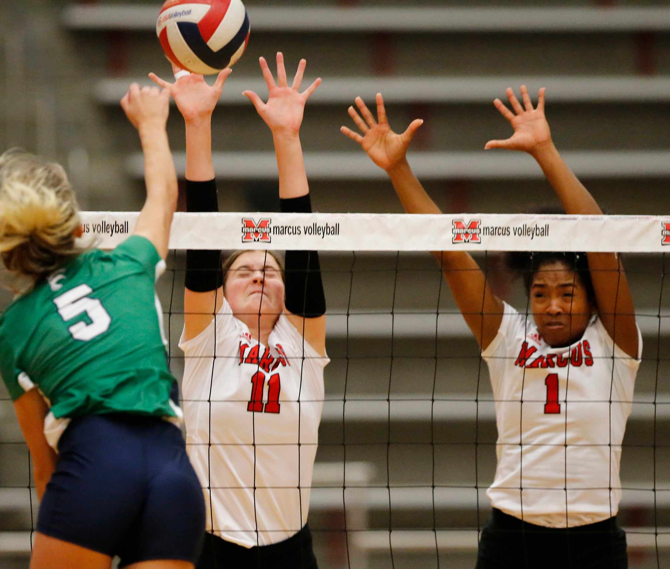 Marcus setter Lexi Godbey (11) and middle Madison Dyer (1) attempt to block a hit by Eaton...