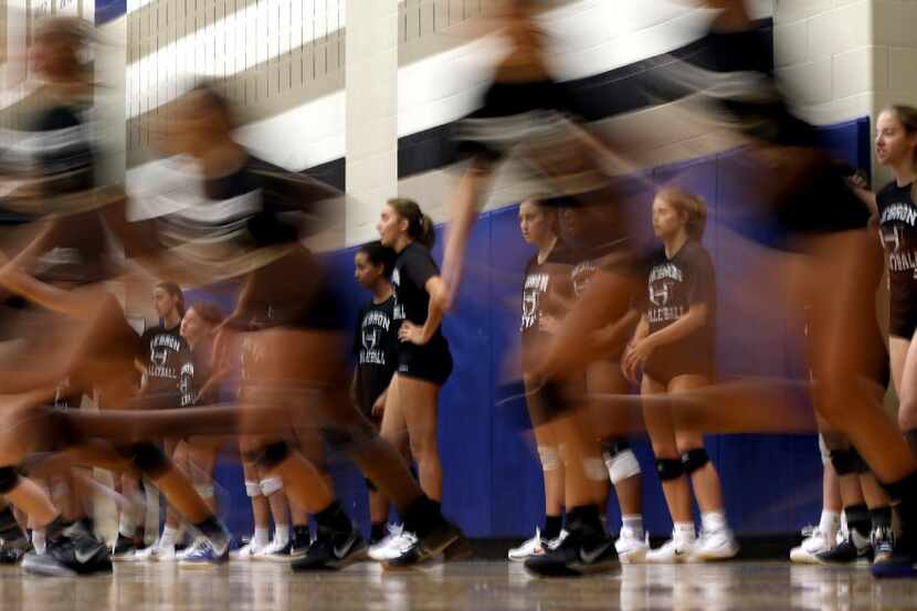 Hebron volleyball players get practice under way with running drills after being split into...