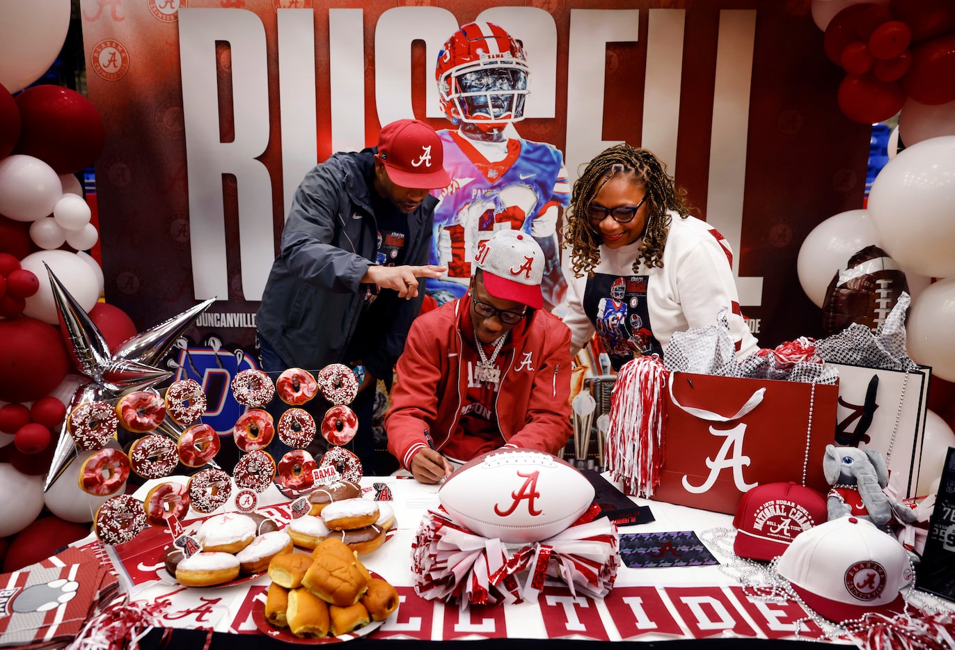 Alongside his dad Brian Russell and mom April Moore, Duncanville quarterback Keelon Russell...