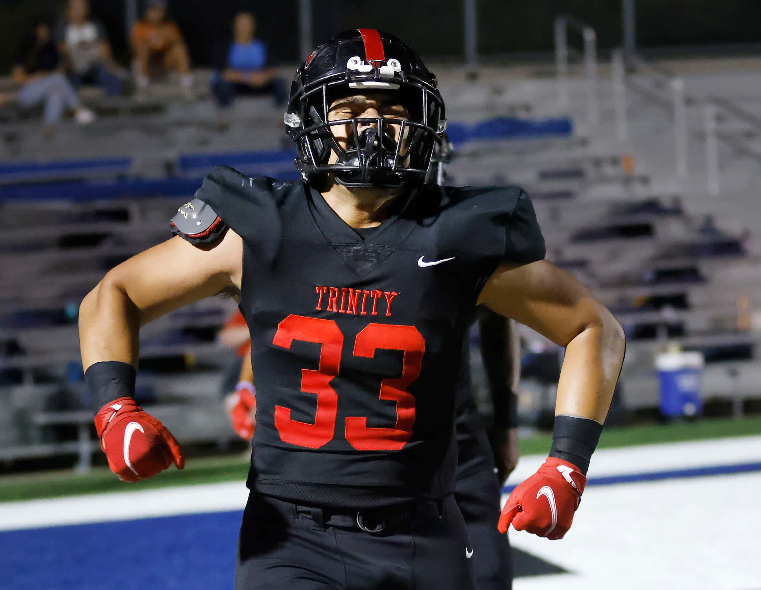 Euless Trinity full back Buddy Leota (33) celebrates his second quarter touchdown against...