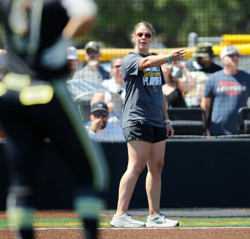 Forney assistant coach Georgia Capell directs a base runner during Game 2 of a regional...