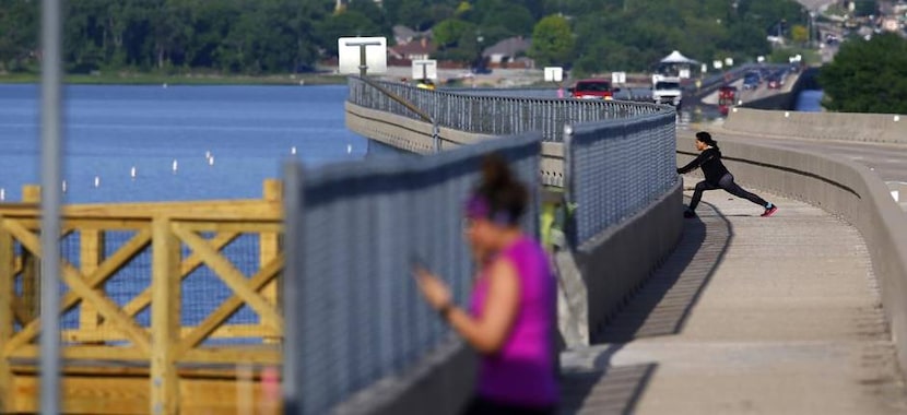 
Joggers stretch before beginning their runs on the Highway 66 bridge near Scenic Point Park...