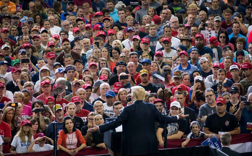 Attendees listen as President Donald Trump speaks at a campaign-style rally at the Ford...