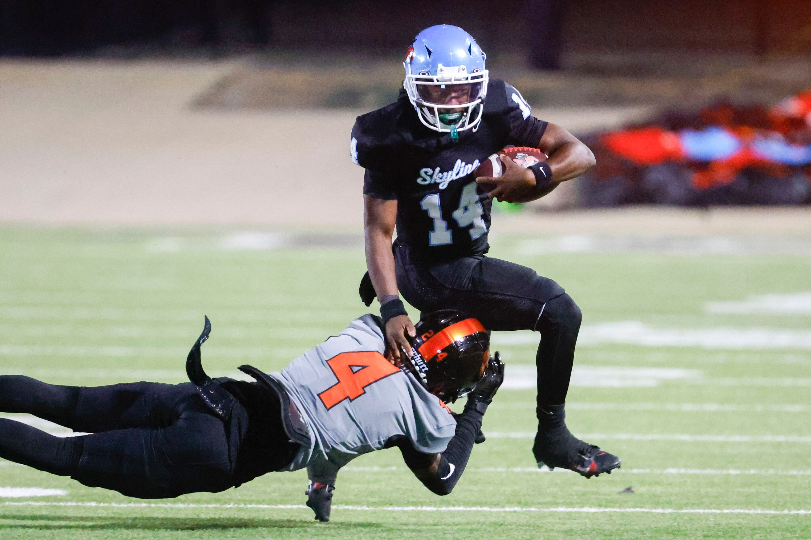 Skyline High’s Donte Ware (14) runs past Lancaster high’s Victor Lincoln during the first...