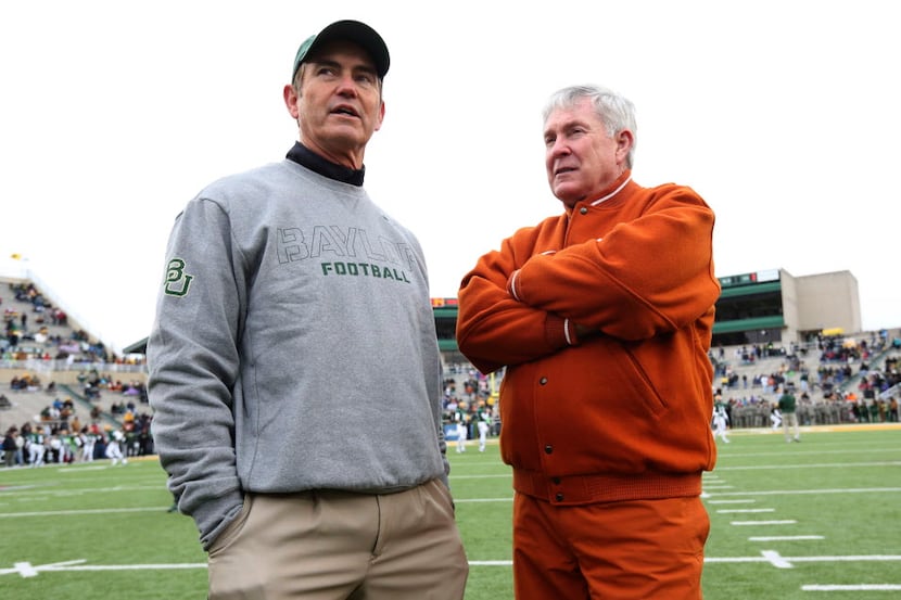 Baylor head coach Art Briles, left, visits with Texas head coach Mack Brown before an NCAA...