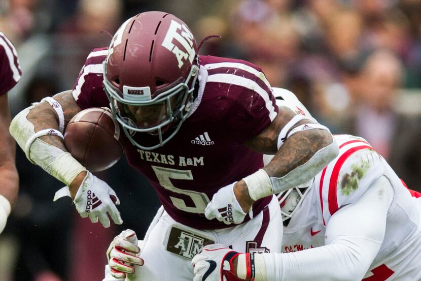 Texas A&M Aggies running back Trayveon Williams (5) hangs on to the ball with his arm while...