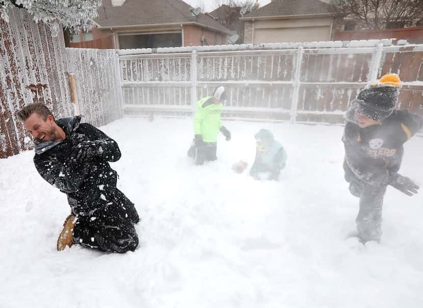 Jeramy Melchiorre (left), gets hit with a snowball thrown by his son, Christian Melchiorre,...
