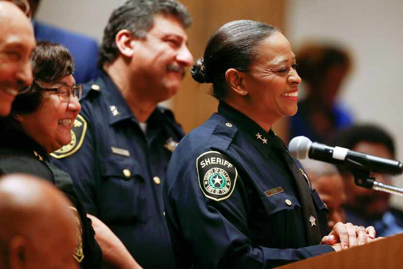 Lupe Valdez (izq.) sonríe al tiempo que Marian Brown (al frente) es nombrada sheriff...