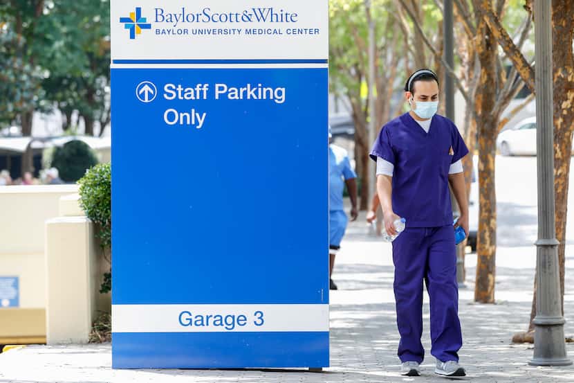 A health care worker walks outside Baylor University Medical Center on July 28, 2021, in...