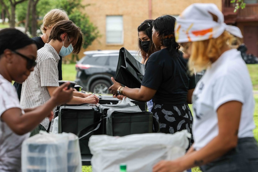 Volunteers and staff from Feed the People work together to pack boxes with food to deliver...