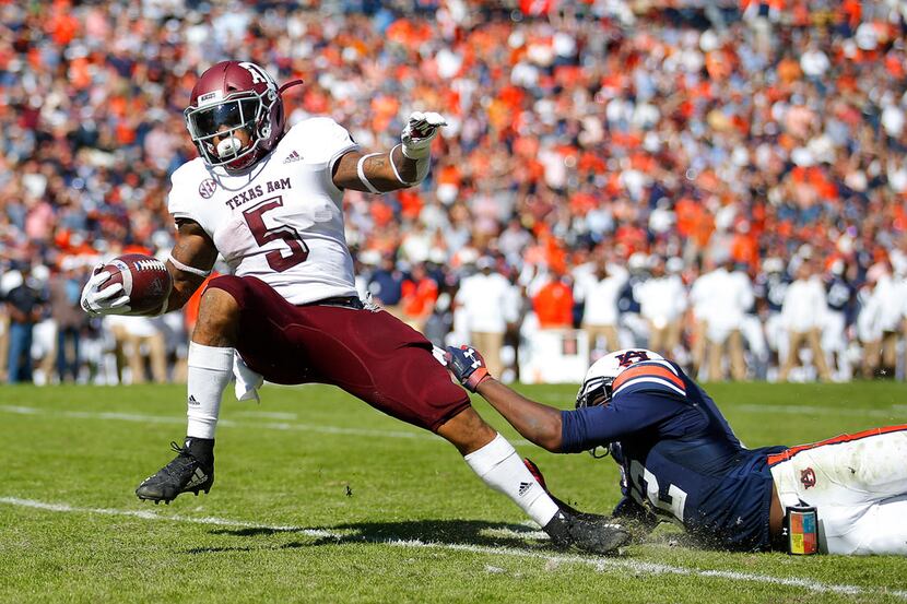 Texas A&M running back Trayveon Williams (5) breaks the tackle of Auburn defensive back...