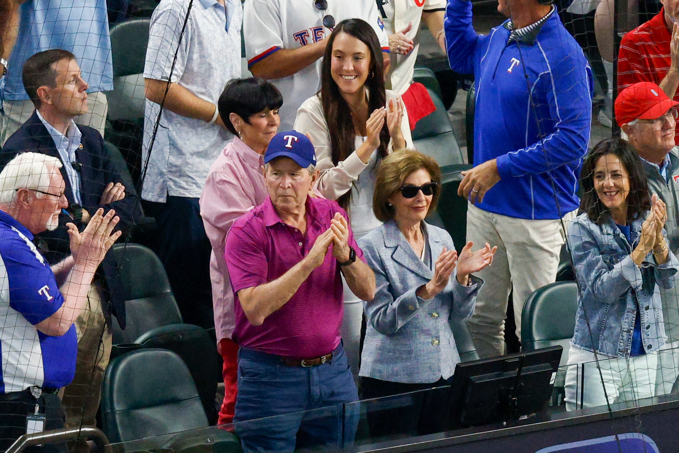 Former President George W. Bush and Laura Bush stand and cheer after Texas Rangers first...