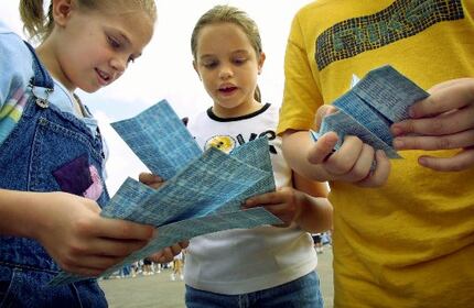 Corinne Pedersen, 10, Hannah Sifuentes, 9, and Preston Cooke, 13, count out their sheets of...