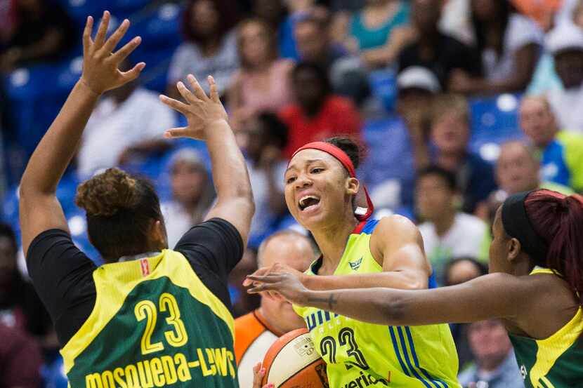 Dallas Wings forward Aerial Powers (23) looks for a passing lane around Seattle Storm...