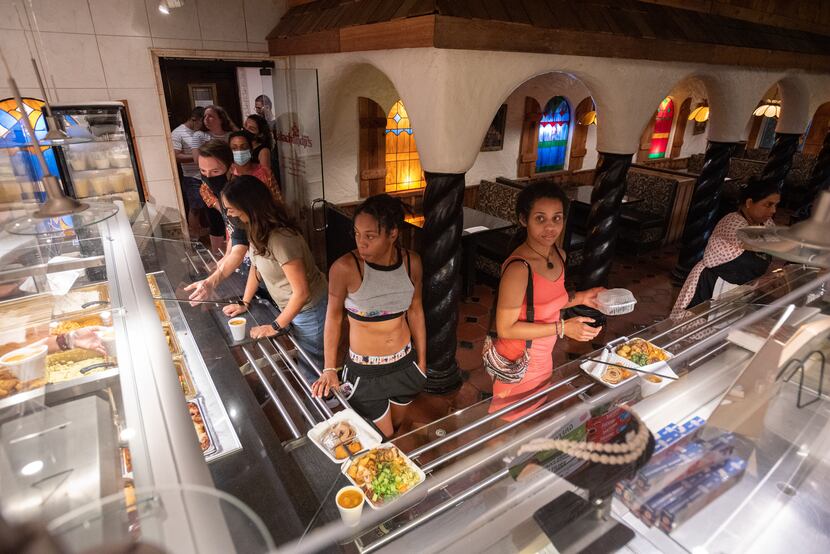 Shar Ma'at, left, and Jupiter-Morgan Dixon wait to pay for their meal in the buffet line at...