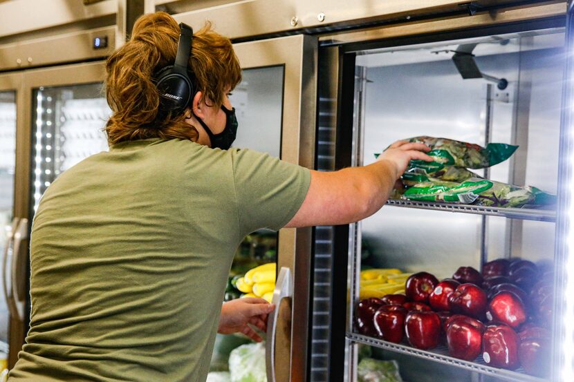 Preston Westbrook loads produce into one of the store's coolers.