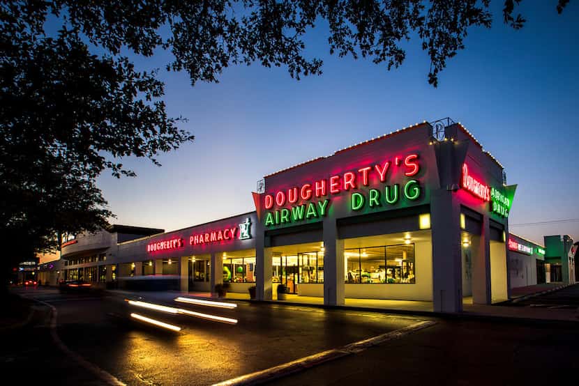 Neon lights up the flagship Dougherty's Pharmacy in Preston Royal Village as night falls.