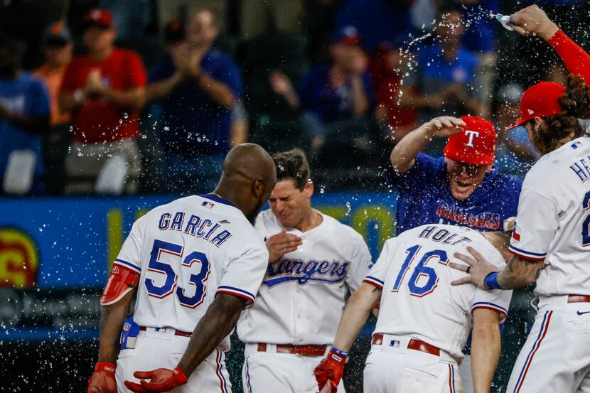 Texas Rangers celebrate after second baseman Brock Holt (16) singles out to centerfield,...