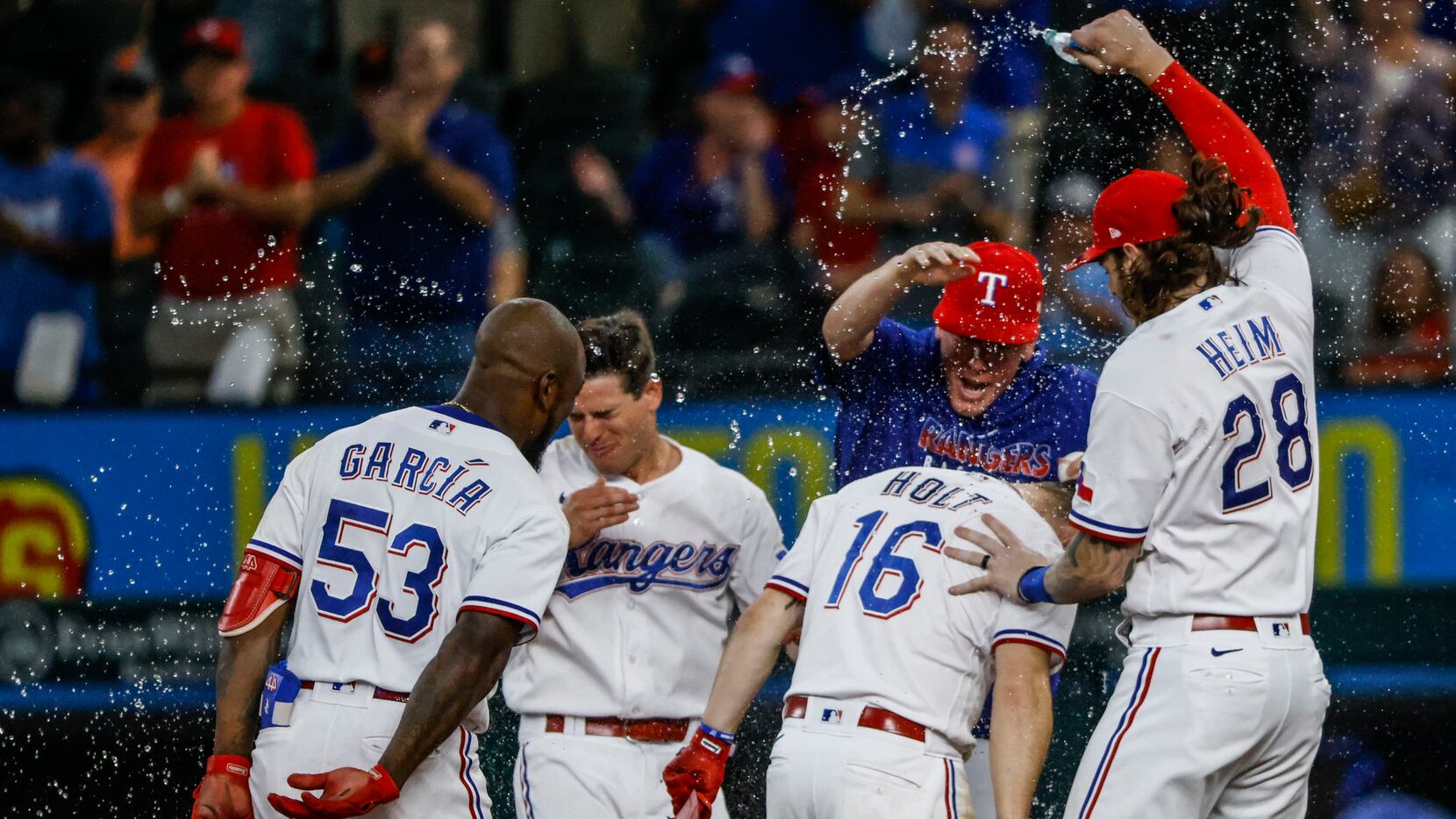 Texas Rangers' Brock Holt, left, and Isiah Kiner-Falefa, right, celebrate  Holt's walk-off single in the 11th inning of the team's baseball game  against the San Francisco Giants in Arlington, Texas, Wednesday, June