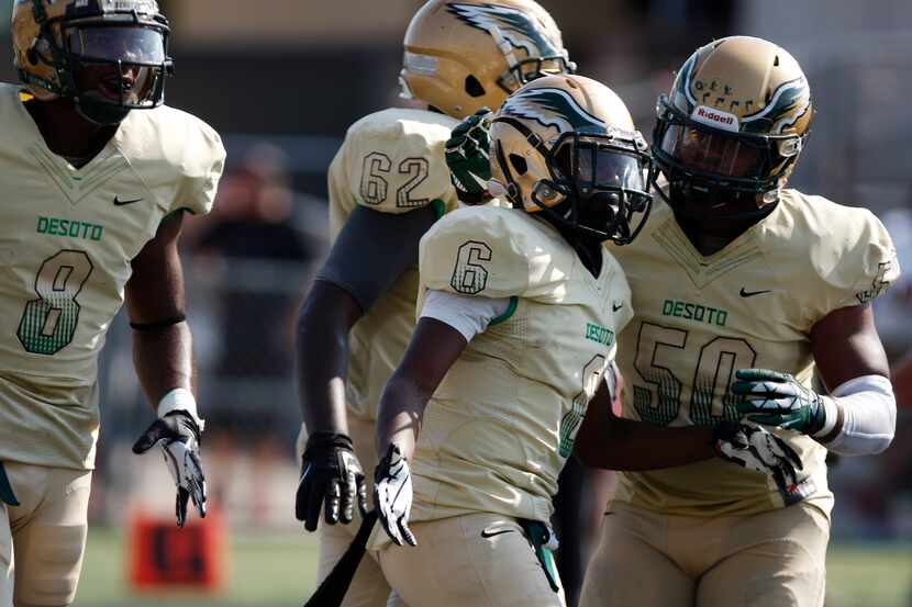 DeSoto's Jaimon Peterson (6) and Herman Samples (50) celebrate after Peterson scored a...