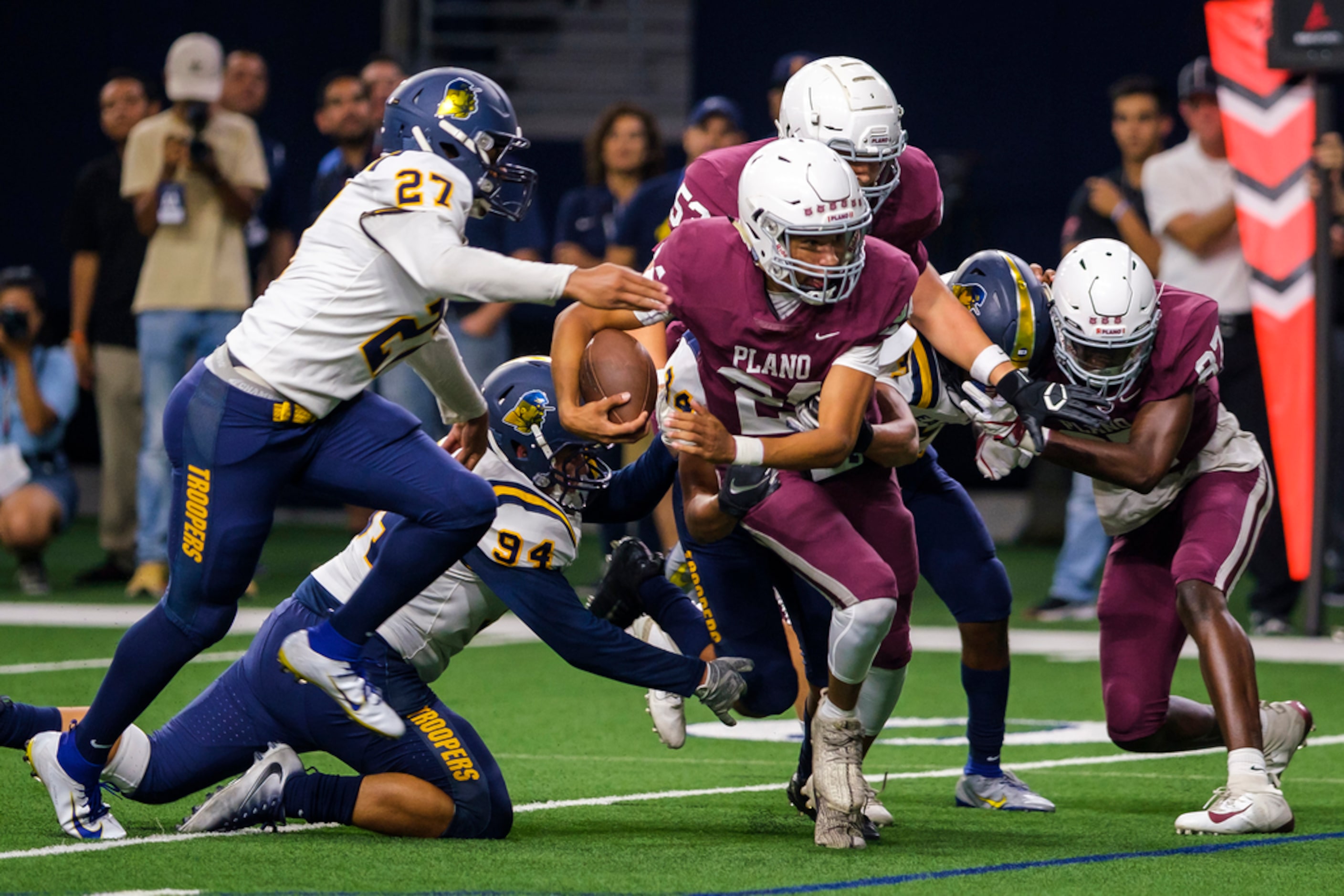 Plano quarterback Oliver Towns (24) slips past El Paso Eastwood defensive linemen Takeem...