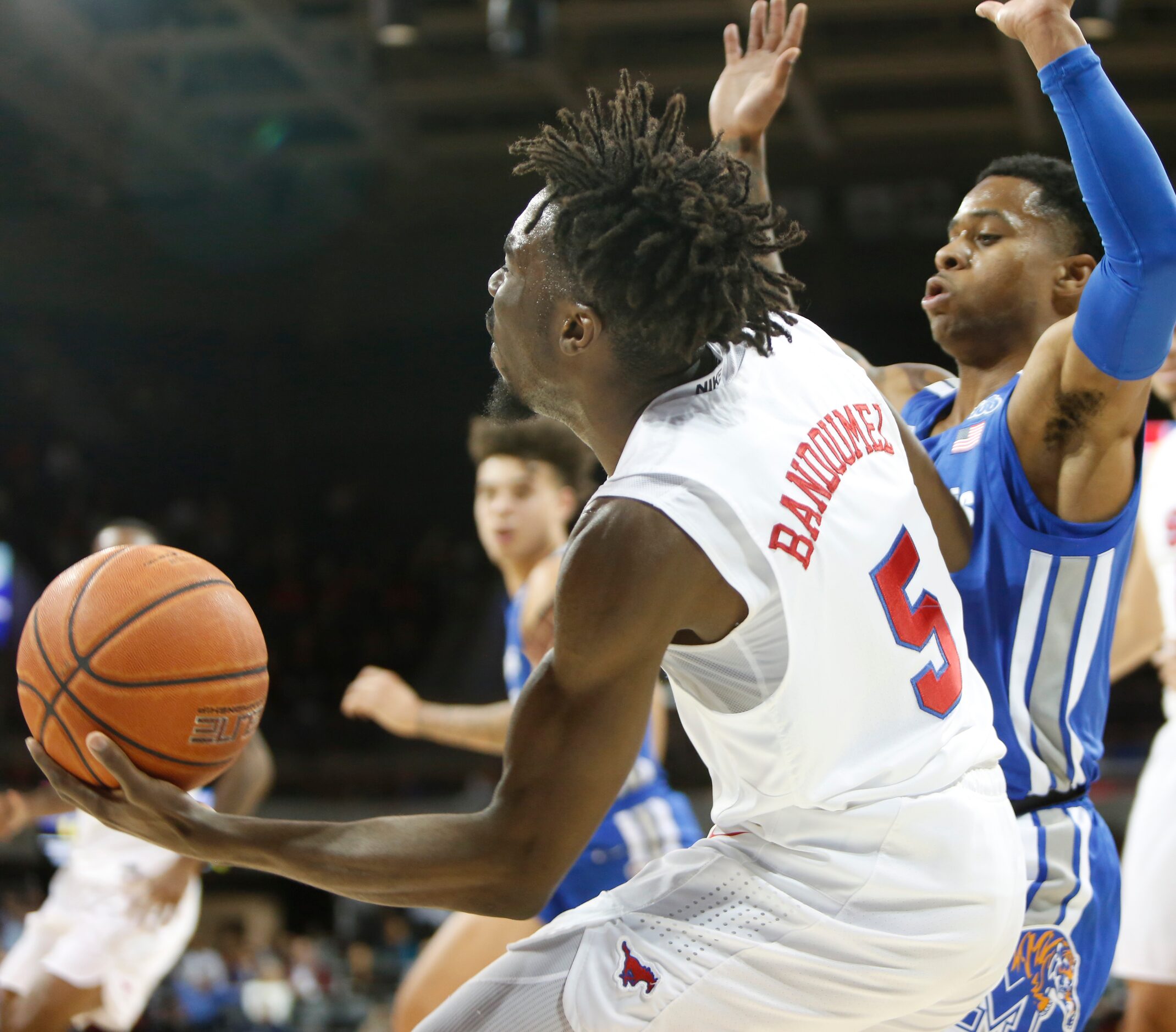 SMU guard Emmanuel Bandoumez (5) drives the baseline against the defense of Memphis guard...