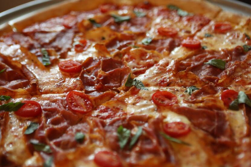 A whole New York pie with toppings at Zoli's New York Pizza Tavern is shown on Saturday,...