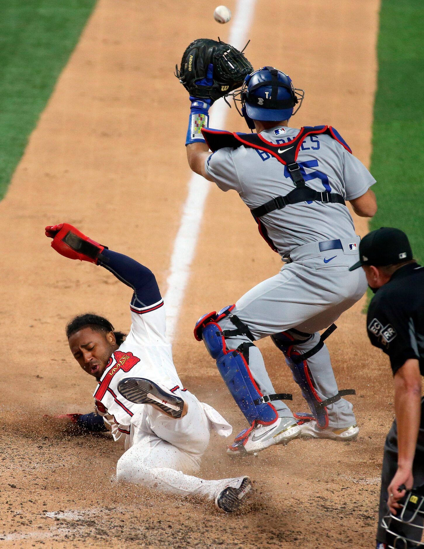 Atlanta Braves second baseman Ozzie Albies (1) slides safely into home plate ahead of the...