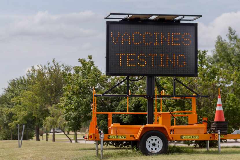 A sign informs drivers of COVID-19 vaccinations and testing outside the Ellis Davis Field...