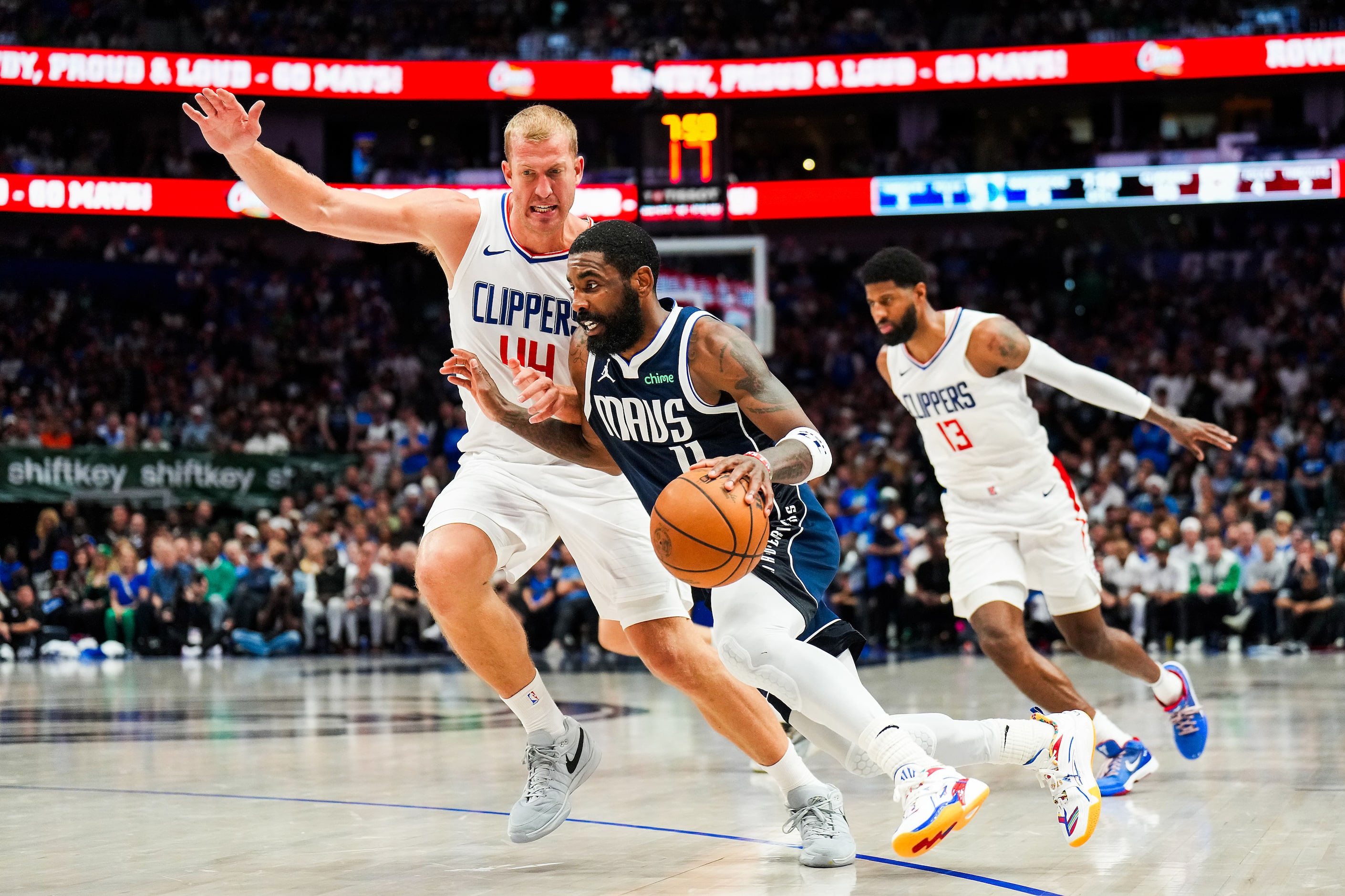 Dallas Mavericks guard Kyrie Irving (11) drives around LA Clippers center Mason Plumlee (44)...