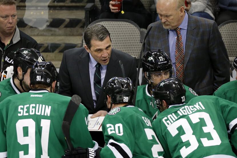 Dallas Stars assistant coach Curt Fraser, center, gathers his players during a break in the...
