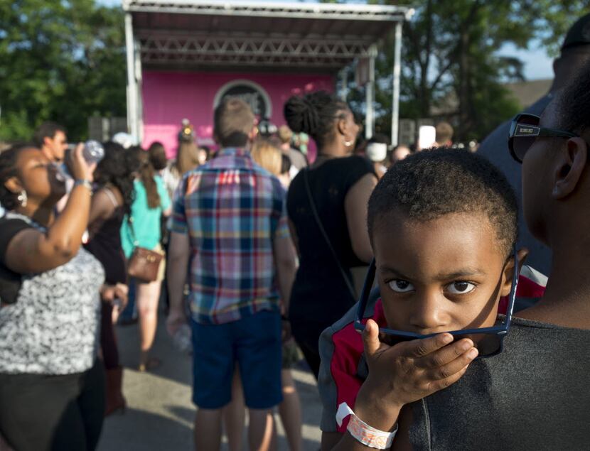 Four-year-old Caden Price listens to the Rebirth Brass Band in the arms of his mother,...