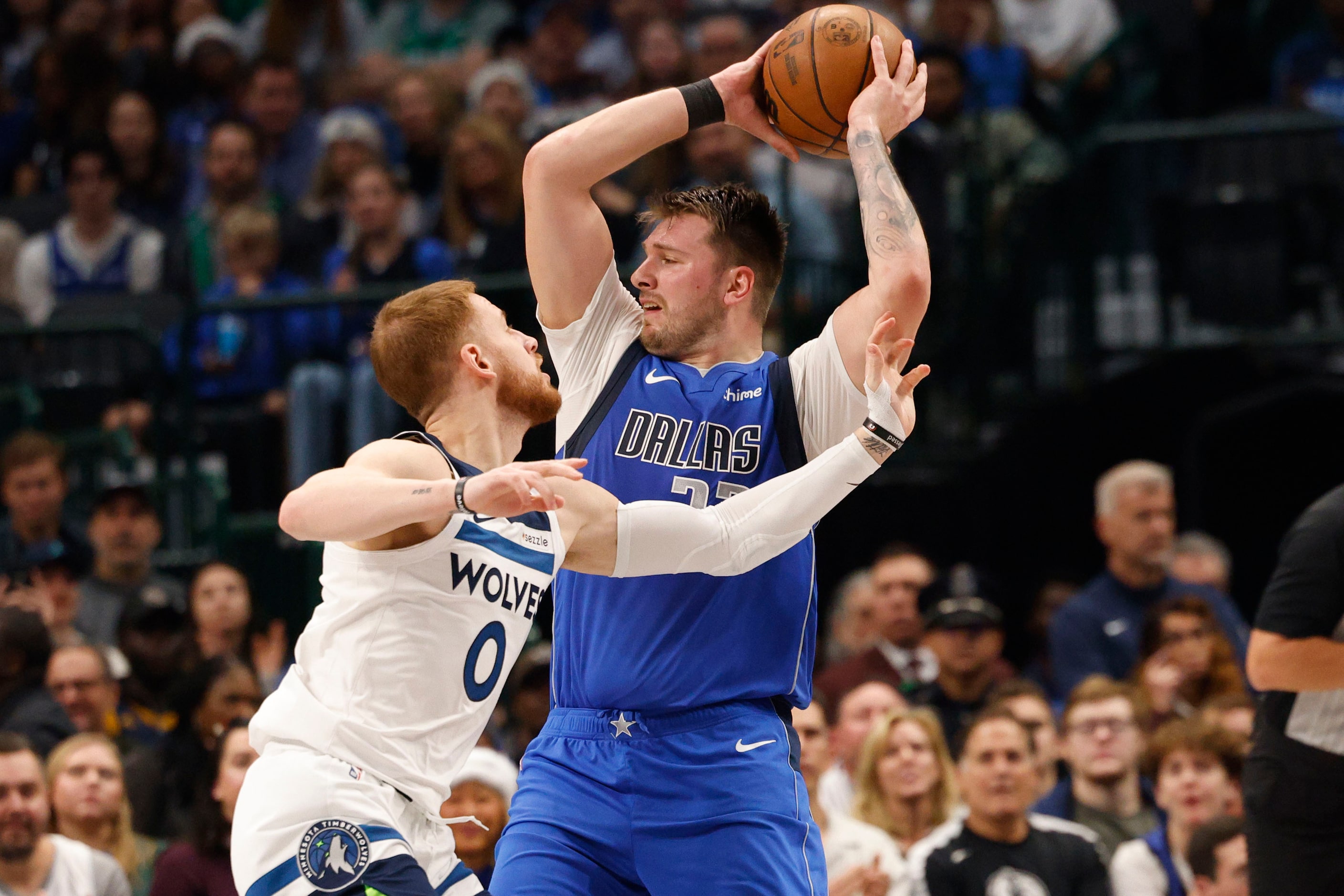 Dallas Mavericks guard Luka Doncic (77) keeps the ball away from Minnesota Timberwolves...