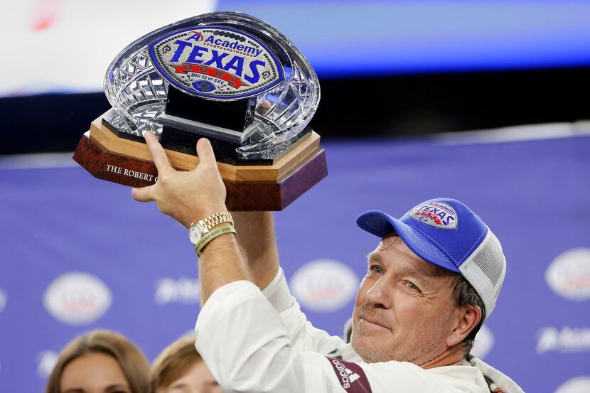 Texas A&M coach Jimbo Fisher holds up the Texas Bowl trophy after the team's 24-21 win over...