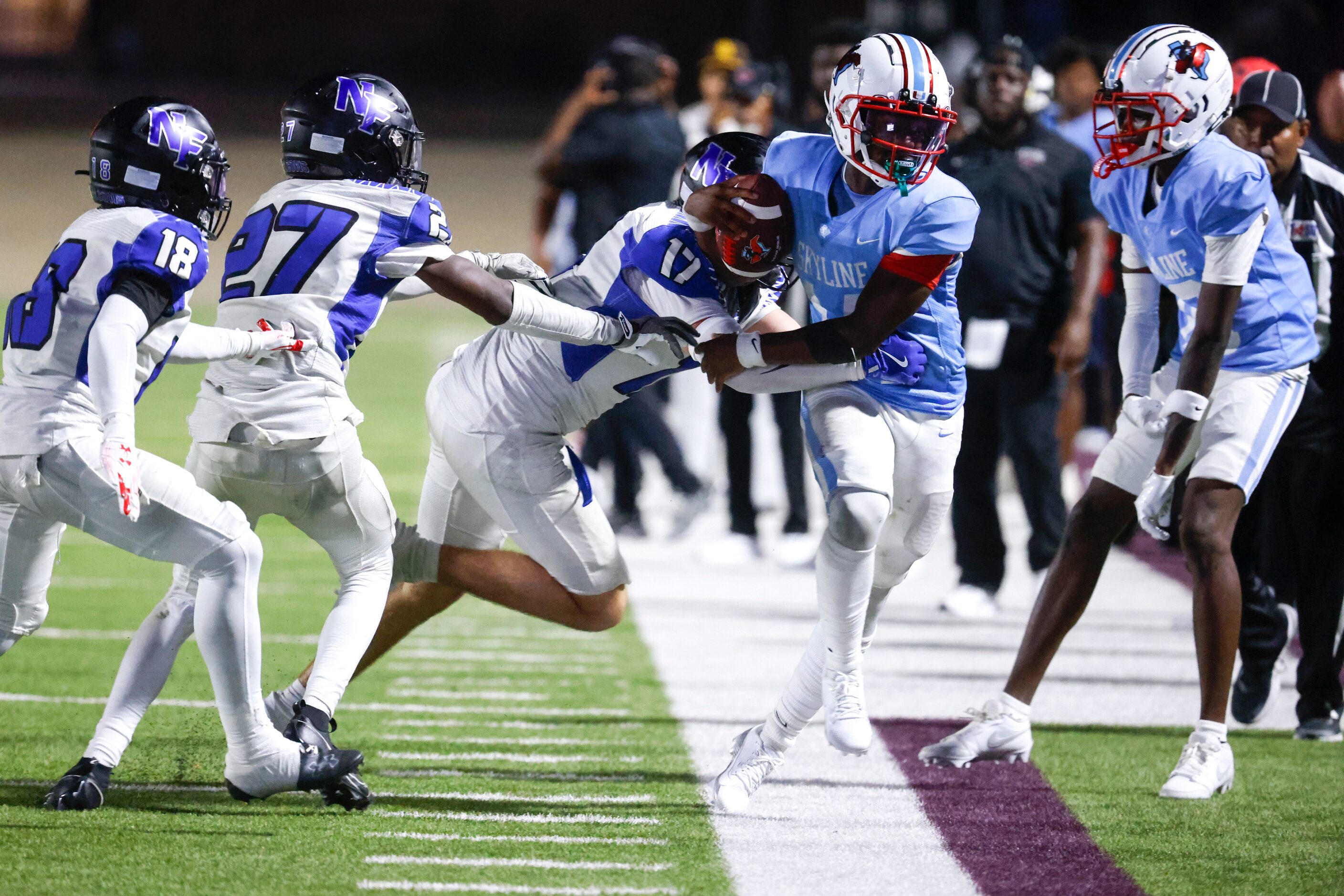 Skyline High’s QB Donte Ware (centered) is tackled out of bounds by North Forney High’s...