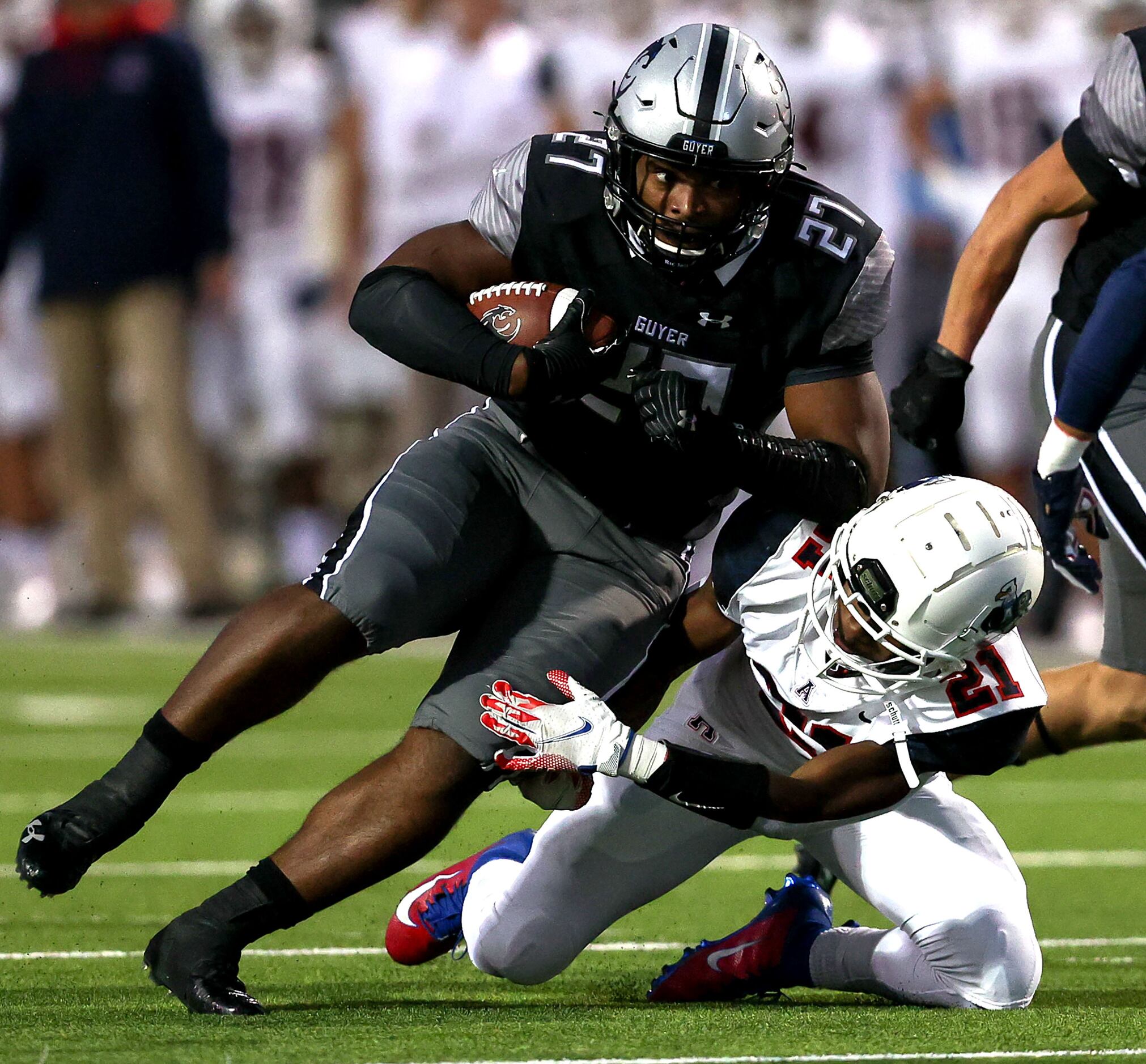 Denton Guyer running back Byron Phillips (27) is stopped for a short gain by Allen defensive...