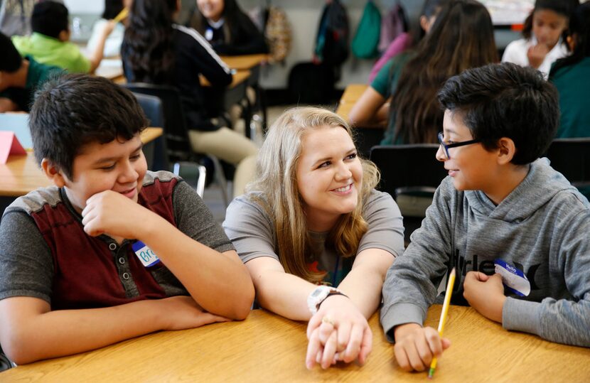 New teacher Caroline Rodgers talks with Brandon Garcia (right) as Brandon Navarr looks on...