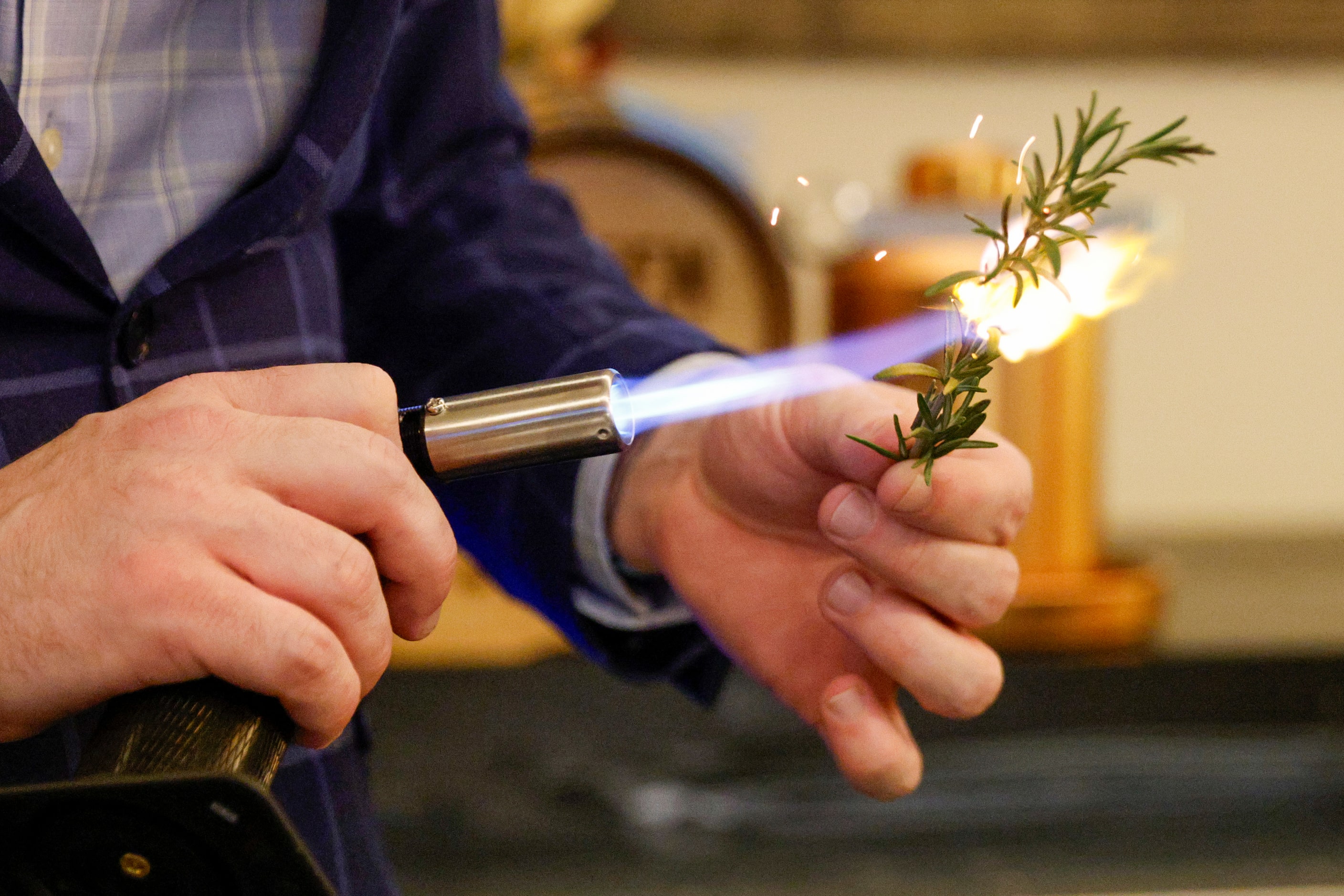 Allen Scott burns rosemary as he prepares the X-Roads cocktail at Boxcar in Dallas.