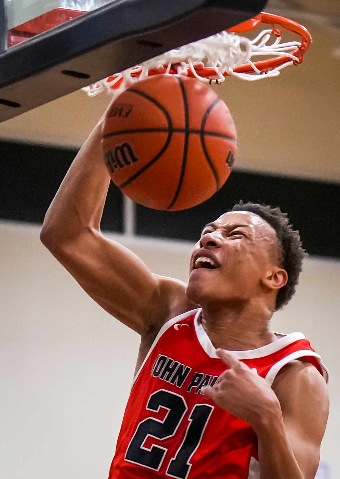 John Paul II's Gabe Warren dunks the ball during a high school basketball game against...